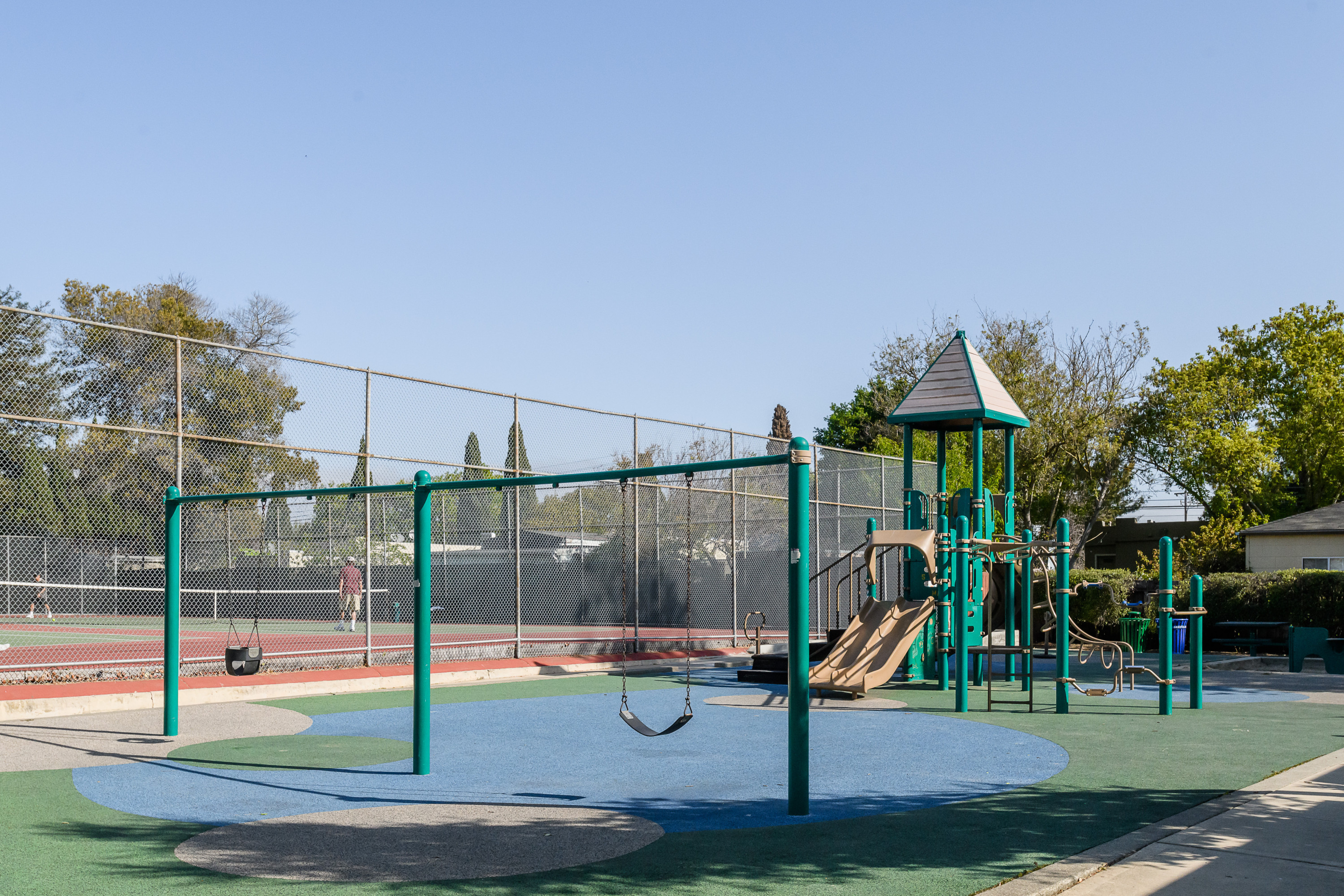 Burlingame Grove tennis court and a slide and green colored poles for support in Burlingame.