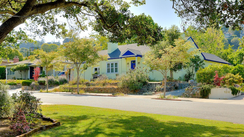 Yellow craftman home with blue overhang  in the Beverly Terrace area in San Carlos
