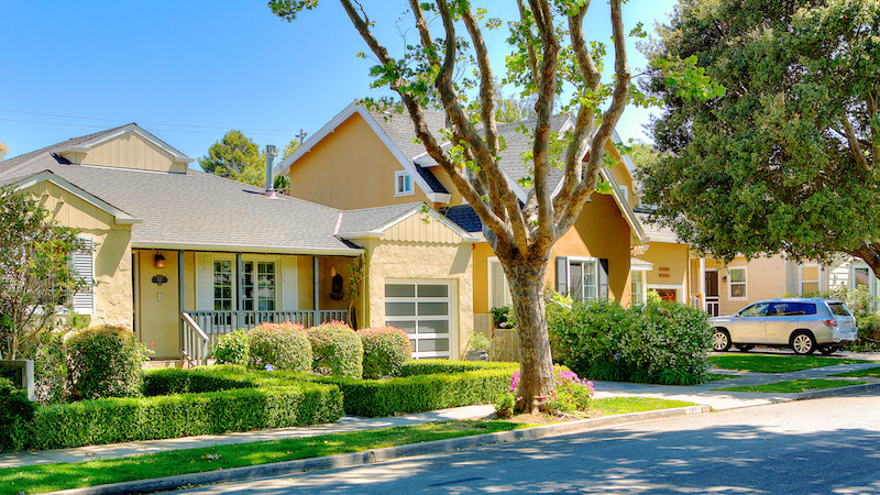 Burlingables home with a yellow colored exterior paint and low hedge bush encirlcling the front yard in Burlingame.