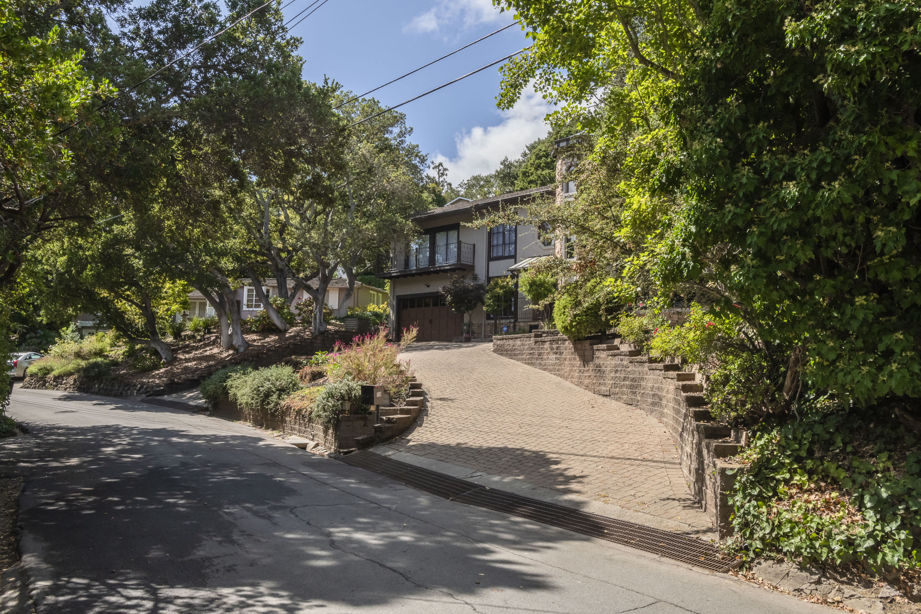 Burlingame Hills brick paved driveway and a sloped front yard with trees in Burlingame.